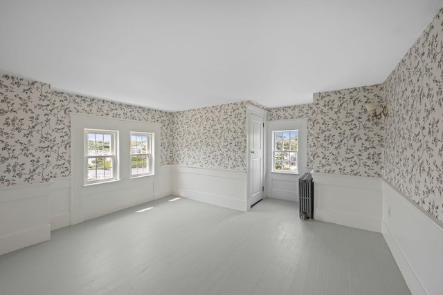 36 Uncle Barneys Rd, West Dennis, MA 02670 - spare room featuring wallpapered walls, wainscoting, and wood finished floors