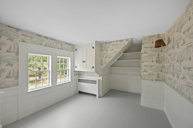 36 Uncle Barneys Rd, West Dennis, MA 02670 - unfurnished bedroom featuring wallpapered walls, radiator, a wainscoted wall, and light wood-style flooring