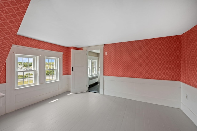 36 Uncle Barneys Rd, West Dennis, MA 02670 - unfurnished room featuring wallpapered walls, a wainscoted wall, radiator heating unit, and light wood finished floors
