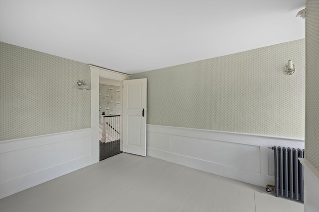 36 Uncle Barneys Rd, West Dennis, MA 02670 - unfurnished room featuring radiator heating unit, a wainscoted wall, and wallpapered walls