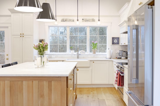 kitchen featuring appliances with stainless steel finishes, sink, a kitchen island, and white cabinets