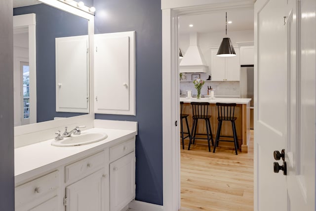 bathroom featuring vanity, wood-type flooring, and backsplash