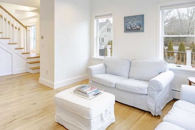 living room with a baseboard heating unit and light hardwood / wood-style floors