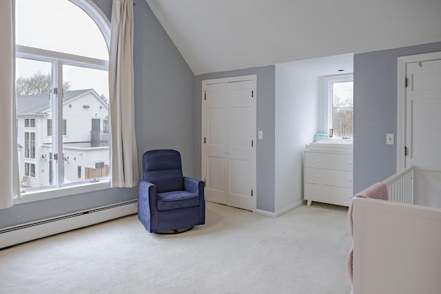 bedroom with baseboard heating, a closet, vaulted ceiling, and light carpet