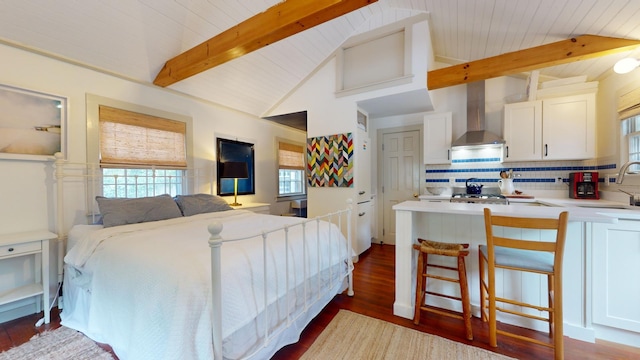 bedroom featuring sink, dark hardwood / wood-style floors, and vaulted ceiling with beams