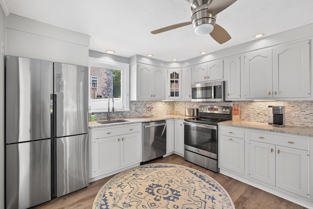 24 Tabor Rd, Forestdale, MA 02644 - kitchen with appliances with stainless steel finishes, decorative backsplash, glass insert cabinets, white cabinetry, and recessed lighting