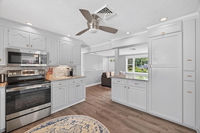 24 Tabor Rd, Forestdale, MA 02644 - kitchen with appliances with stainless steel finishes, white cabinets, backsplash, a ceiling fan, and wood finished floors