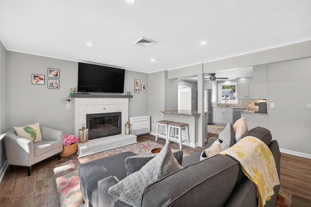 24 Tabor Rd, Forestdale, MA 02644 - living area featuring ceiling fan, wood finished floors, a brick fireplace, crown molding, and recessed lighting