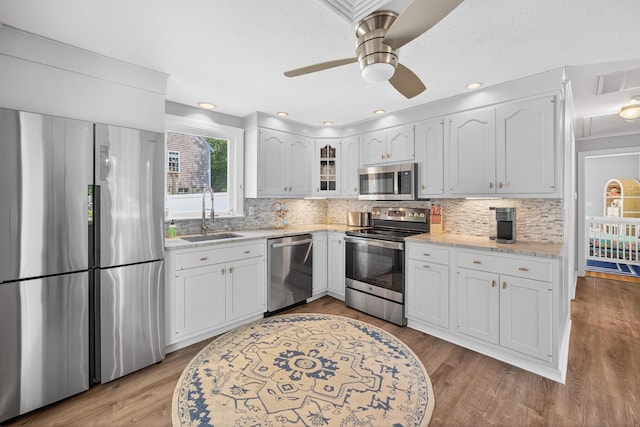 24 Tabor Rd, Forestdale, MA 02644 - kitchen with stainless steel appliances, backsplash, and white cabinetry
