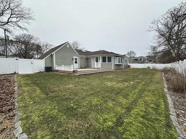 exterior space featuring central AC unit, a lawn, and a deck