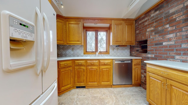 kitchen featuring stainless steel dishwasher, white refrigerator with ice dispenser, sink, and tasteful backsplash