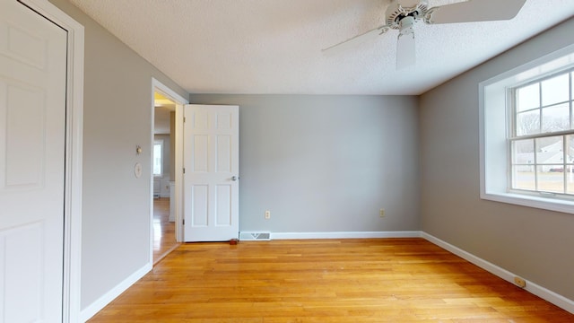 unfurnished bedroom with ceiling fan, light hardwood / wood-style flooring, and a textured ceiling