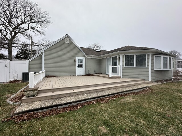 rear view of house with a deck, central AC unit, and a yard