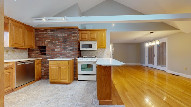 kitchen with white appliances, tasteful backsplash, vaulted ceiling, and hanging light fixtures