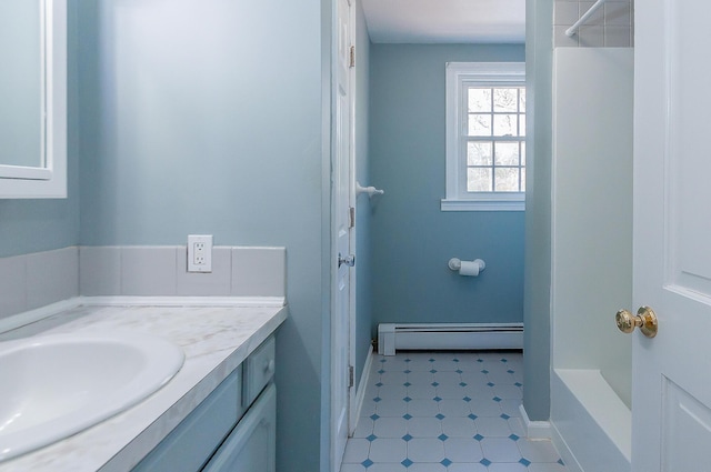 full bath with a baseboard radiator, vanity, and tile patterned floors