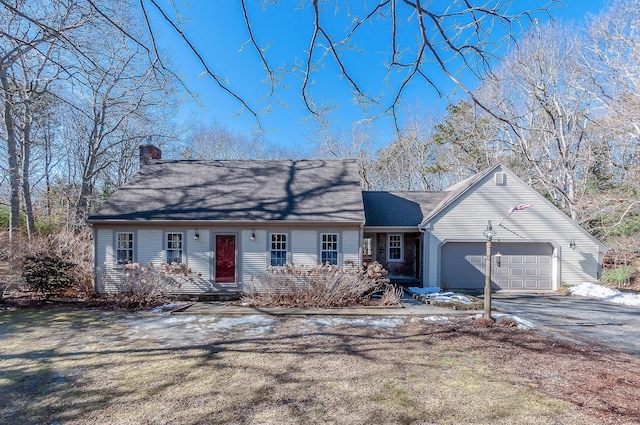 view of front of home with aphalt driveway, a chimney, and an attached garage