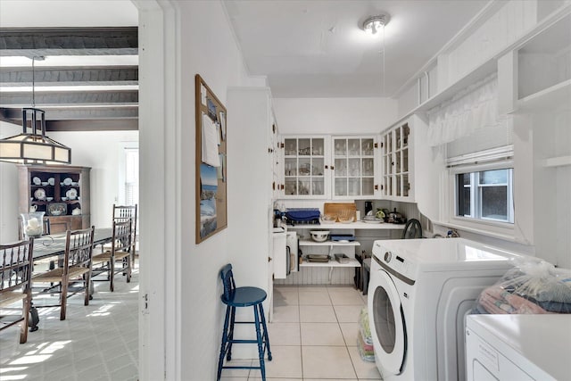 laundry area featuring light tile patterned flooring, plenty of natural light, and separate washer and dryer