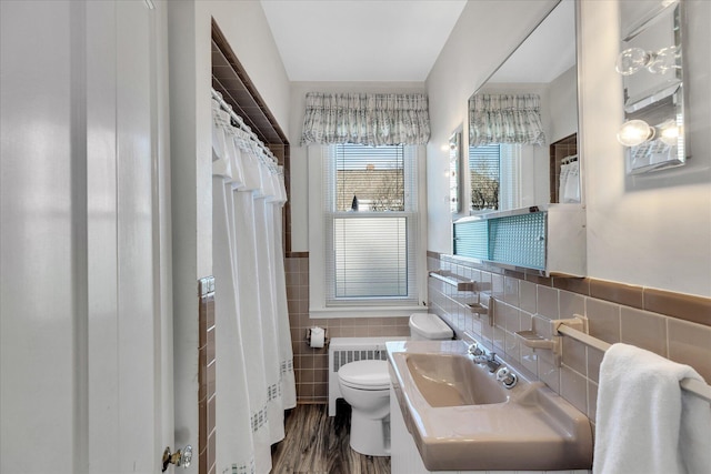 bathroom with wood-type flooring, sink, toilet, and tile walls