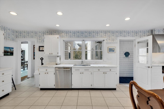 kitchen with sink, white cabinetry, light tile patterned floors, and stainless steel dishwasher