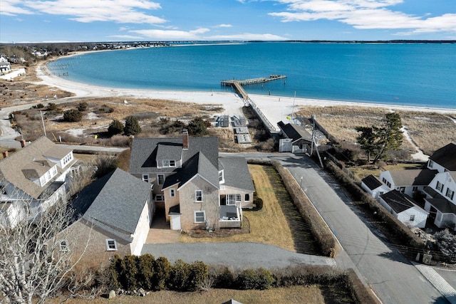 birds eye view of property with a water view and a beach view