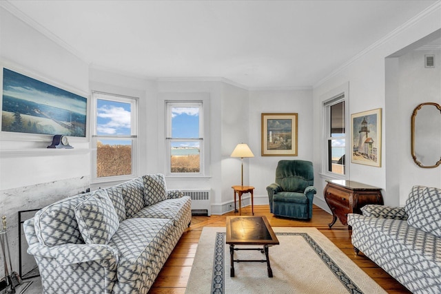 living room featuring radiator heating unit, light hardwood / wood-style floors, and ornamental molding