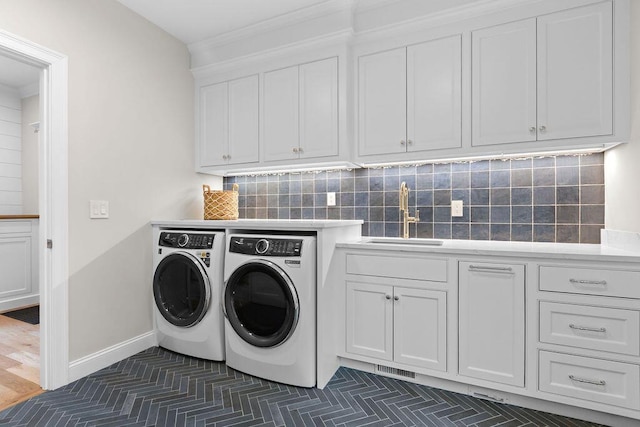 64 Pershing Ln, Orleans, MA 02653 - laundry area featuring independent washer and dryer, cabinet space, and ornamental molding