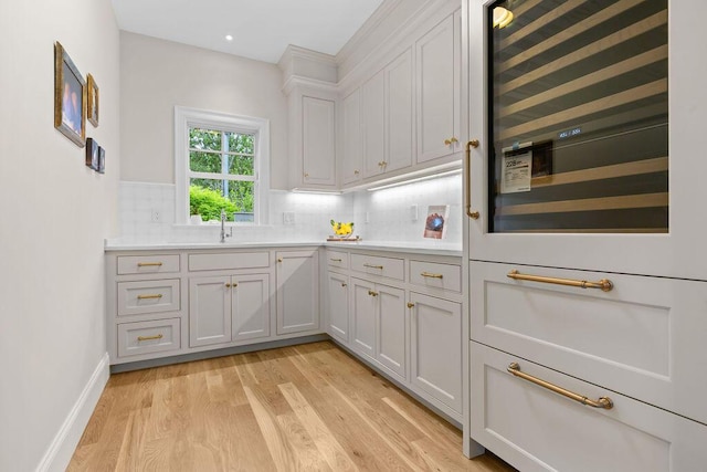 64 Pershing Ln, Orleans, MA 02653 - kitchen featuring beverage cooler, light wood finished floors, backsplash, light countertops, and recessed lighting