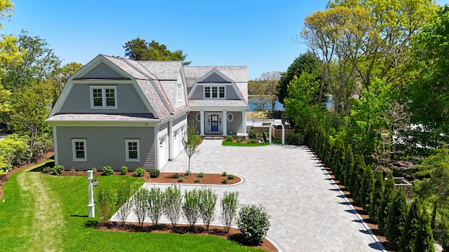 64 Pershing Ln, Orleans, MA 02653 - shingle-style home featuring a gambrel roof, decorative driveway, a front lawn, and a garage