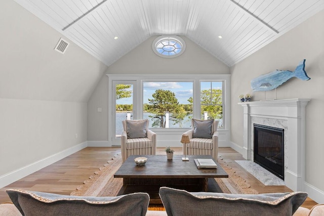 64 Pershing Ln, Orleans, MA 02653 - sitting room featuring plenty of natural light, vaulted ceiling, a high end fireplace, and light wood finished floors