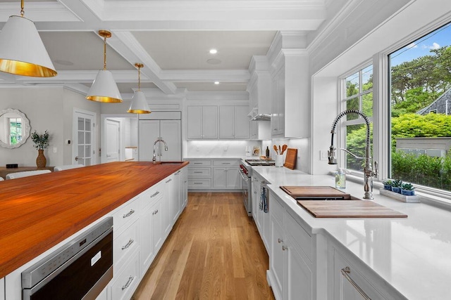 64 Pershing Ln, Orleans, MA 02653 - kitchen featuring wooden counters, premium appliances, a sink, beamed ceiling, and white cabinetry