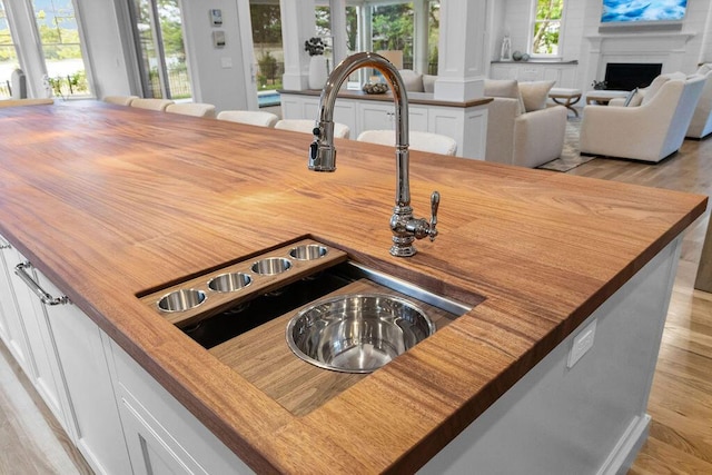 64 Pershing Ln, Orleans, MA 02653 - detailed view of butcher block countertops, light wood-style flooring, and white cabinetry