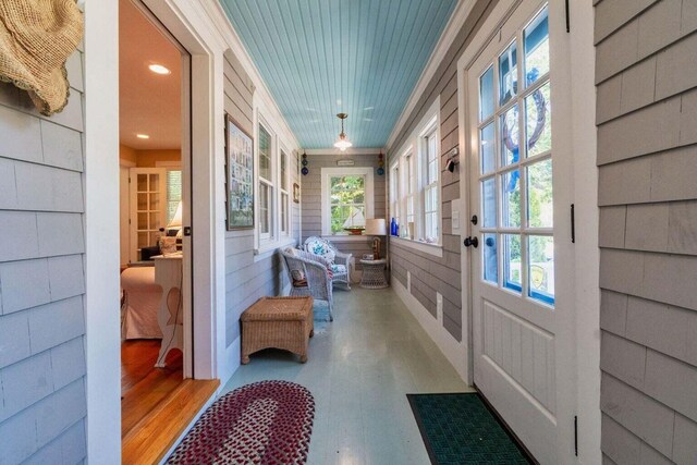 mudroom featuring wood finished floors and a sunroom