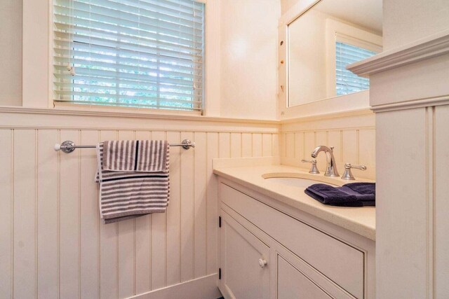 bathroom with radiator heating unit, wainscoting, and vanity