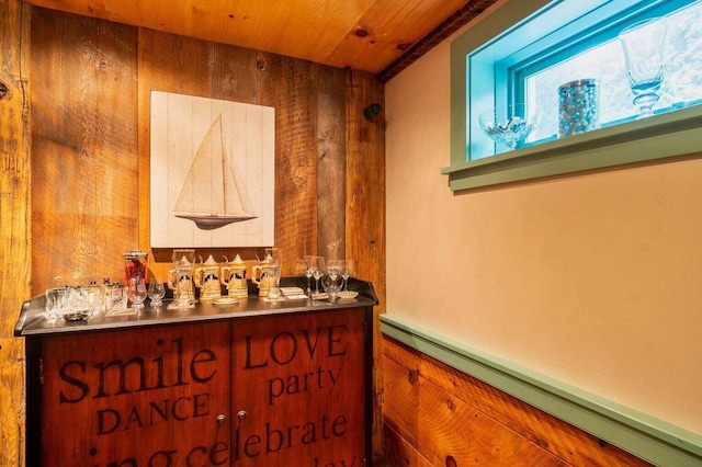 interior space with wood walls, baseboard heating, and wooden ceiling