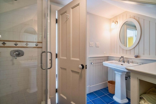 bathroom featuring sink, wooden walls, tile patterned floors, and an enclosed shower