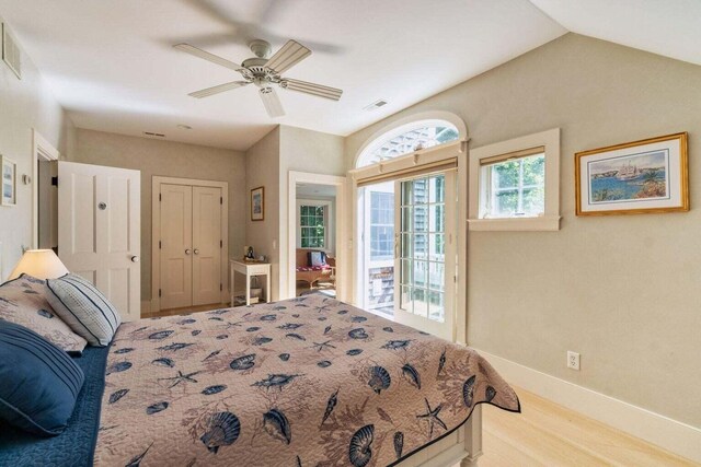 bedroom featuring visible vents, baseboards, wood finished floors, access to outside, and vaulted ceiling