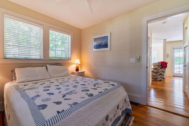 bedroom with hardwood / wood-style floors and access to outside