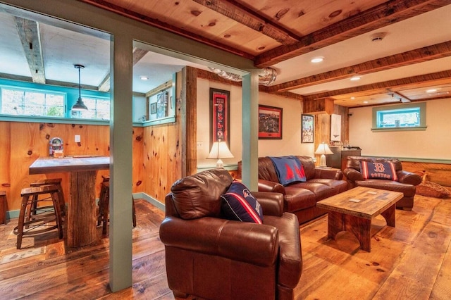 living room featuring beamed ceiling, a bar, wood walls, and wood-type flooring