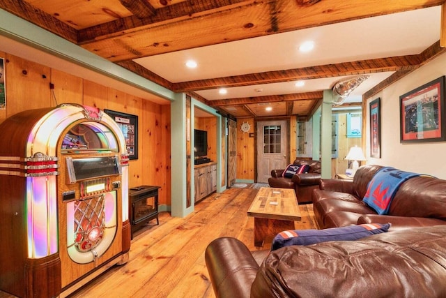 living room featuring light wood-type flooring, beamed ceiling, and wooden walls