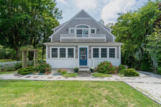 view of front of house with a balcony and a front lawn