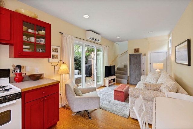48 Pleasant St Unit U3, Provincetown, MA 02657 - living room with a wall mounted air conditioner, light wood finished floors, stairs, and recessed lighting