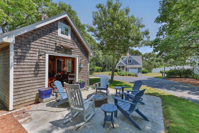 view of patio / terrace featuring a fire pit and an outdoor structure