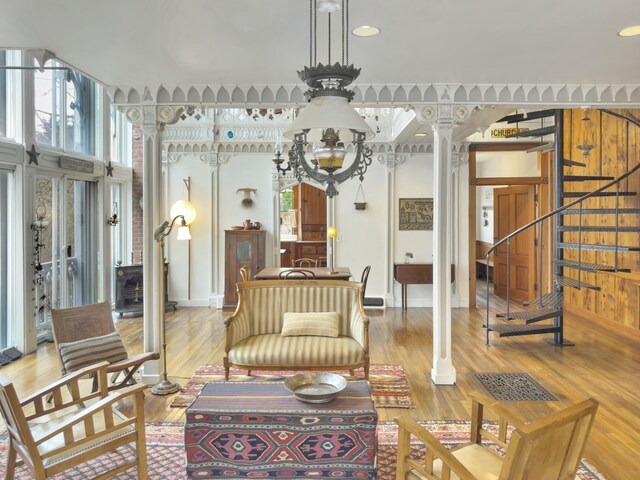 living room with light hardwood / wood-style flooring and ornate columns