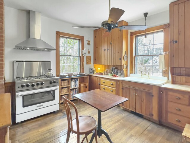 kitchen featuring tasteful backsplash, hardwood / wood-style floors, high end range, and wall chimney exhaust hood