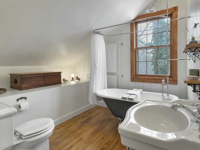 full bathroom featuring lofted ceiling, toilet, sink, hardwood / wood-style flooring, and plus walk in shower