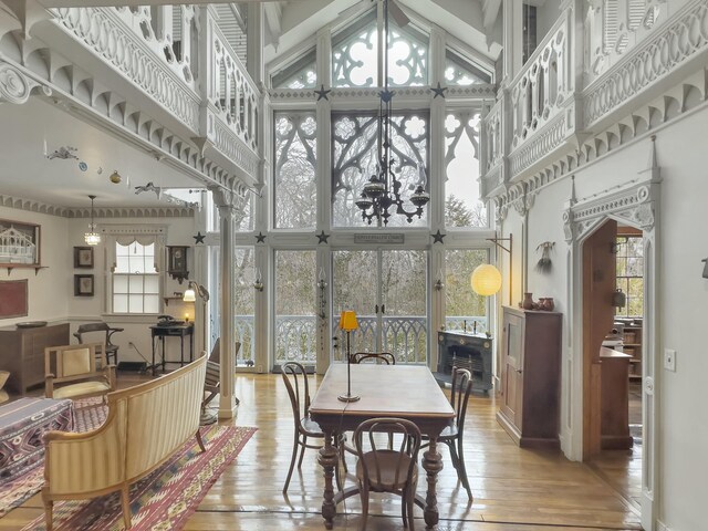 dining area with a towering ceiling and light hardwood / wood-style floors