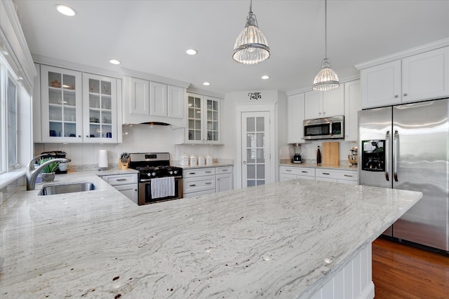 101 Pheasant Hill Cir, Cotuit, MA 02635 - kitchen featuring appliances with stainless steel finishes, a chandelier, light stone countertops, decorative light fixtures, and a peninsula