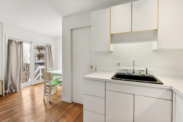 104R Homes Ave, Boston, MA 02123 - kitchen with a sink, light countertops, light wood-style flooring, and white cabinets