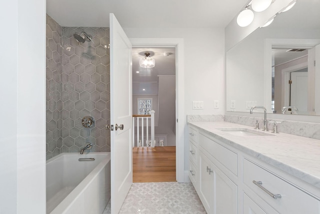 bathroom featuring tiled shower / bath combo and vanity