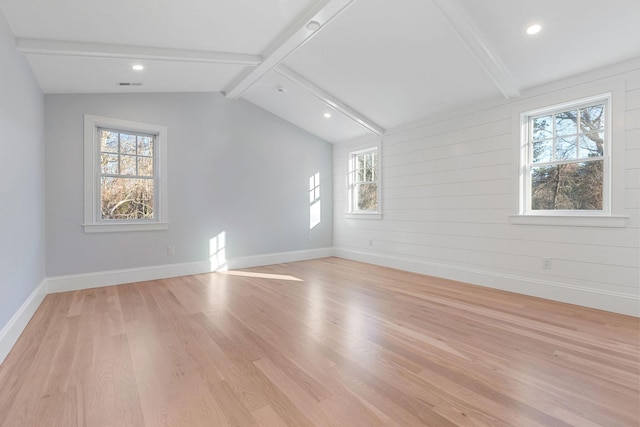 interior space featuring a healthy amount of sunlight, light hardwood / wood-style flooring, and lofted ceiling with beams